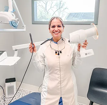 Smiling dentist holding x-ray equipment