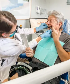 Dentist examining an older man's teeth