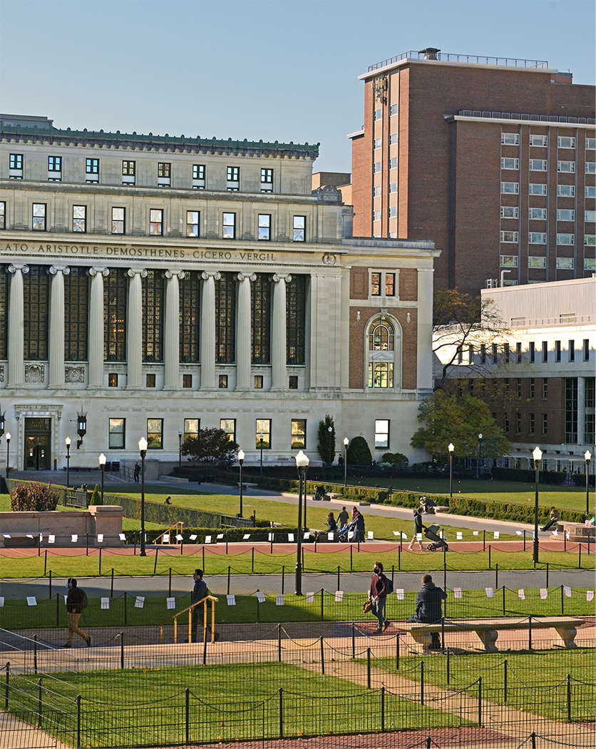 People walking across a courtyard in front of a university building