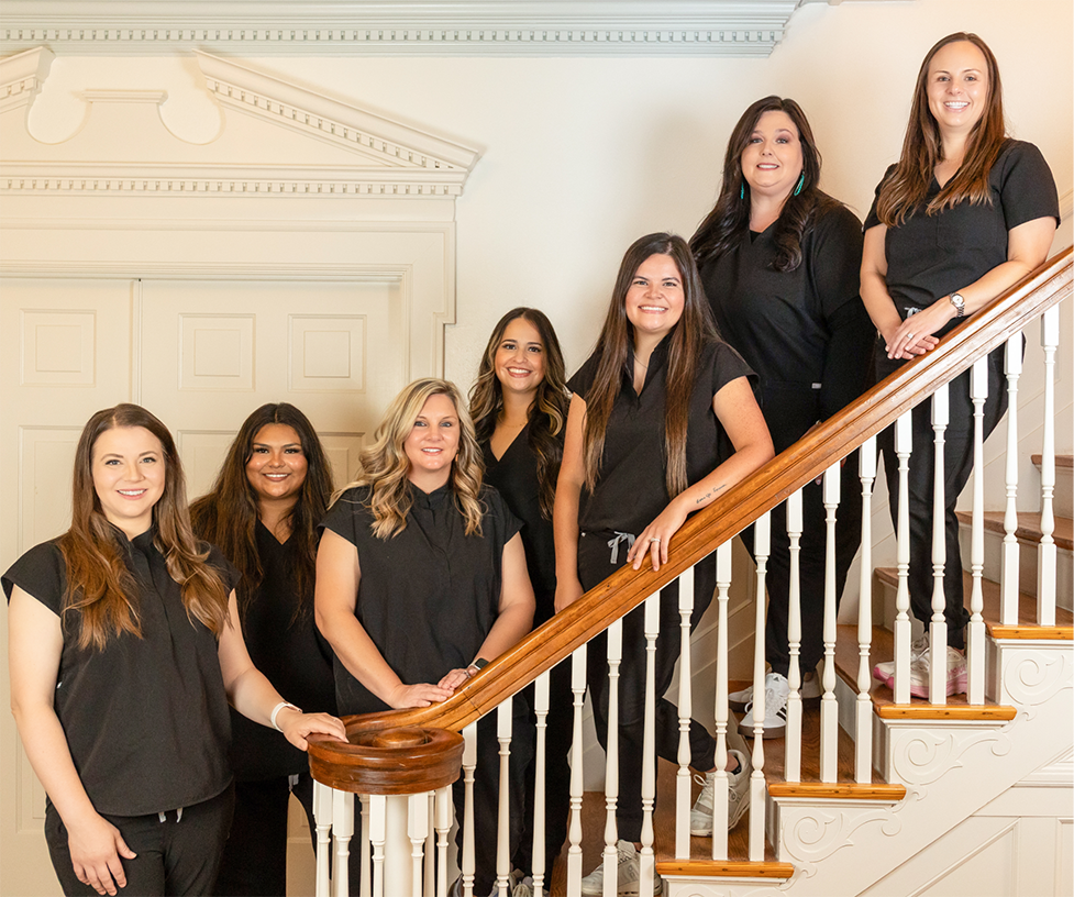 The Keep Smiling Waco team members posing on a staircase