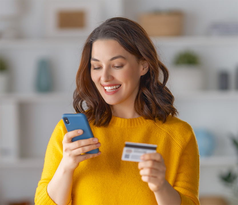 Woman holding a phone and a credit card