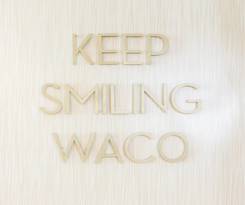 Keep Smiling Waco sign on a wooden background