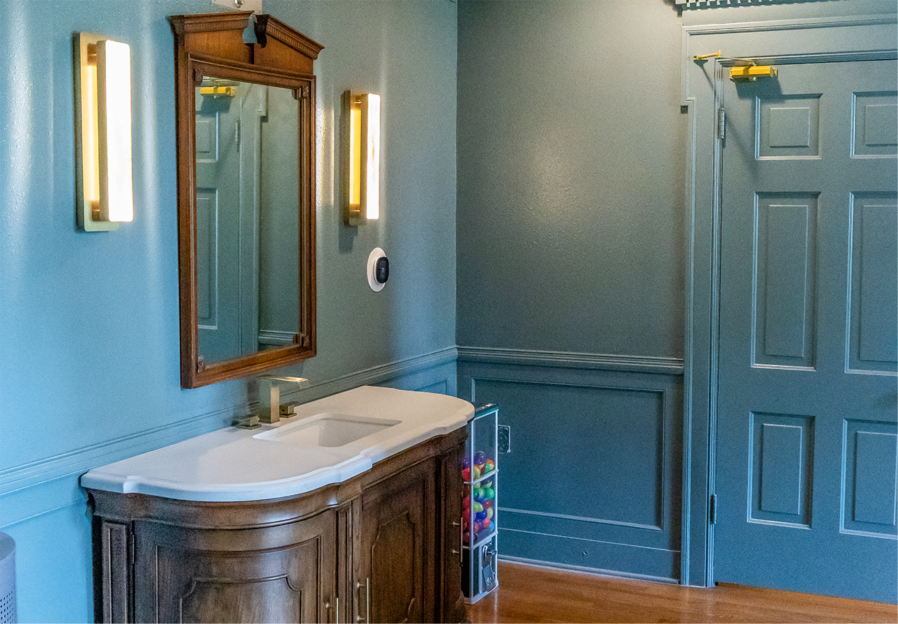 Sink and mirror attached to a dark blue wall