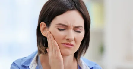 Woman holding the side of her face in pain